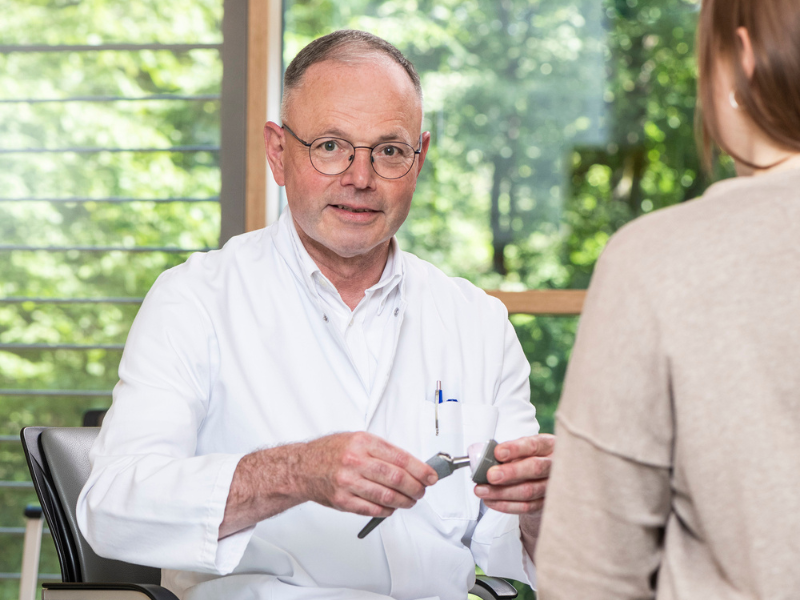 Herr Dr. med. Ambrosius Müller, Leitender Arzt der Klinik für Orthopädie in den DR. ERLER KLINIKEN, im Gespräch mit einer Patientin.