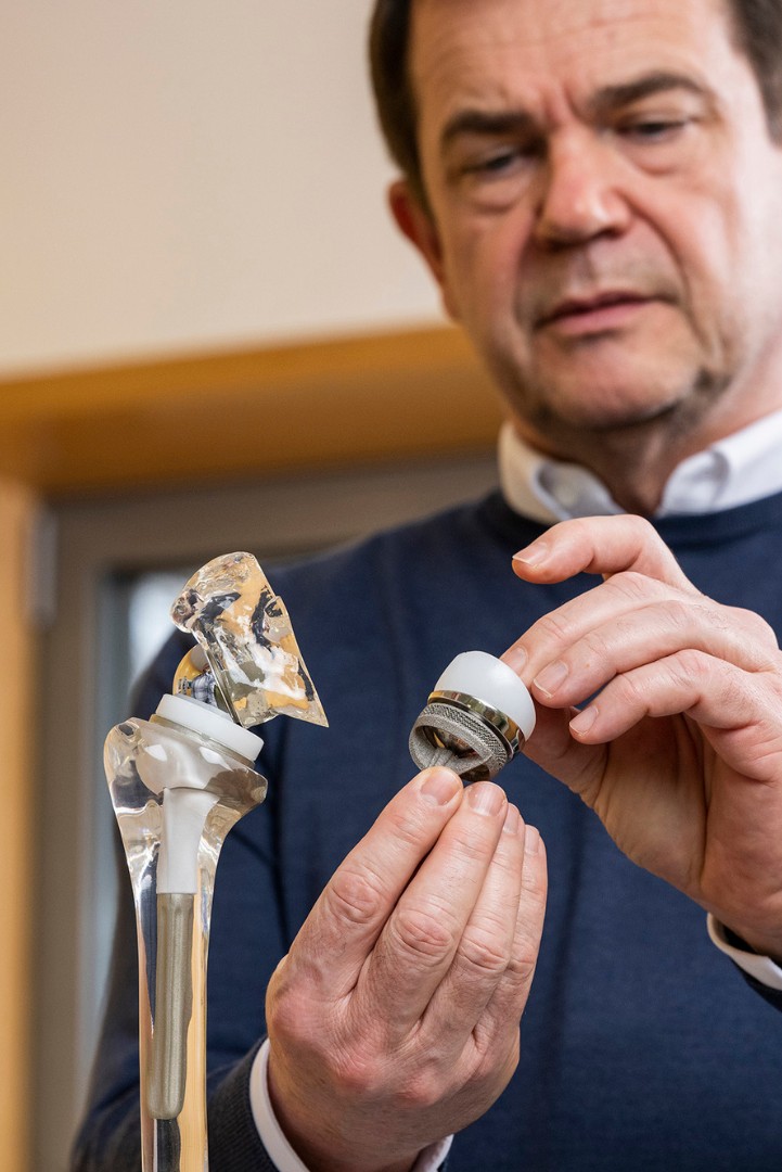 Herr Dr. Anders hält eine Schulterprothese in der Hand. 