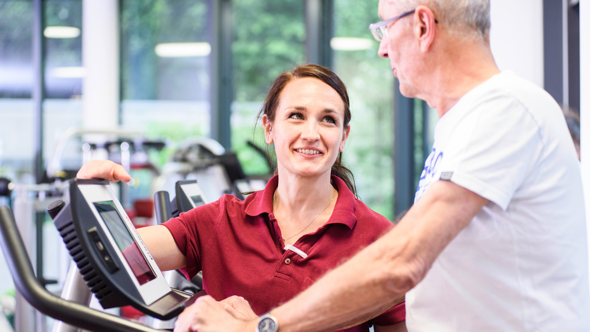 Eine Reha-Therapeutin und ein Patient beim Reha-Sport. 
