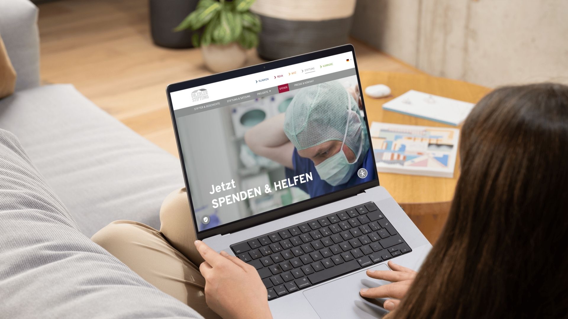 Eine Frau sitzt an ihrem Laptop und schaut sich die Website der DR. FRITZ ERLER STIFTUNG an. 